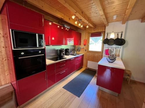 eine Küche mit roten Schränken und einer schwarzen Mikrowelle in der Unterkunft Chalet Châtel, 5 pièces, 8 personnes - FR-1-198-220 in Châtel