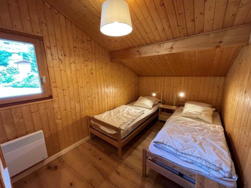 a room with two beds in a wooden cabin at Chalet Châtel, 5 pièces, 8 personnes - FR-1-198-220 in Châtel