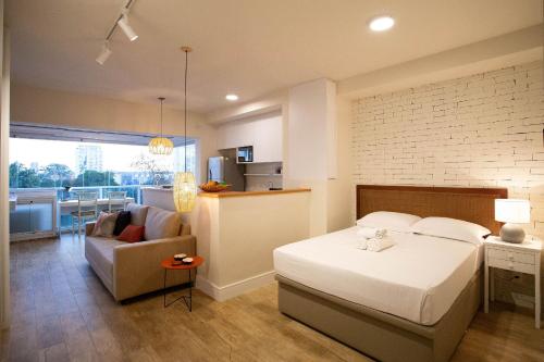 um quarto com uma cama, um sofá e uma cozinha em Condomínio Landing Campo Belo - Studios por temporada em São Paulo