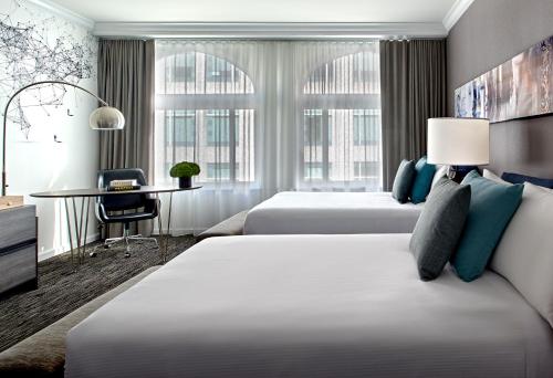 Una habitación de hotel con dos camas y un escritorio. en Hotel Zelos San Francisco, en San Francisco