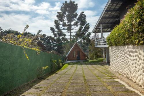 a stone path leading to a house with a fence at Chale com hidromassagem Casa Papai Noel in Campos do Jordão