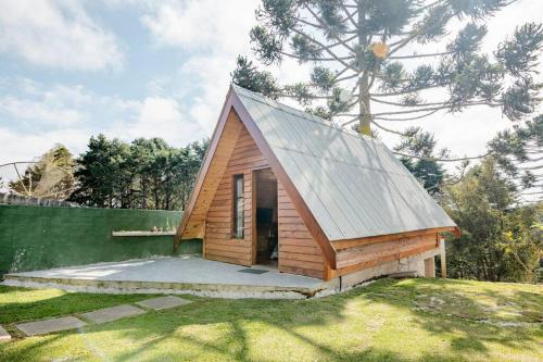 a small cabin with a roof on top of a yard at Chale com hidromassagem Casa Papai Noel in Campos do Jordão