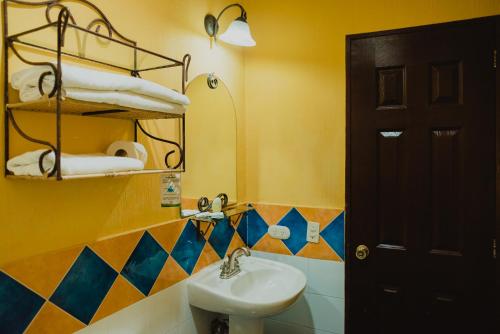 uma casa de banho com um lavatório e um espelho em Hotel Villa Terra em San Salvador