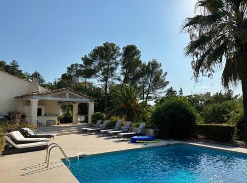 une piscine avec des chaises longues à côté d'une maison dans l'établissement Villa paradisiaque 10 couchages, à Mougins