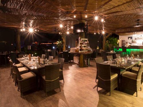 a dining room with tables and chairs and lights at Ara Merú Lodge in Canaima