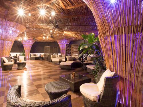 a lobby with couches and chairs and purple lights at Ara Merú Lodge in Canaima