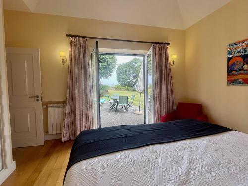 a bedroom with a bed and a sliding glass door at Quinta Das Faias in Camacha