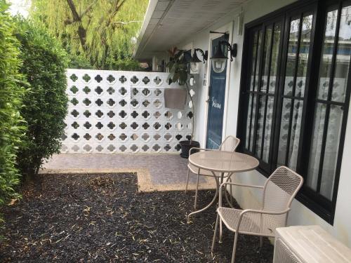 a patio with a table and chairs and a fence at Snoozy Guesthouse in Phuket Town