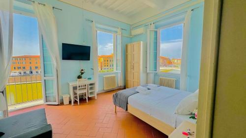 a bedroom with a bed and a tv and windows at B&B - Residenza d'epoca Piazza Cairoli in Pisa