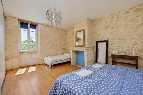 sypialnia z niebieskim łóżkiem i lustrem w obiekcie La maison des vignes w mieście Saint-Pierre-de-Bat