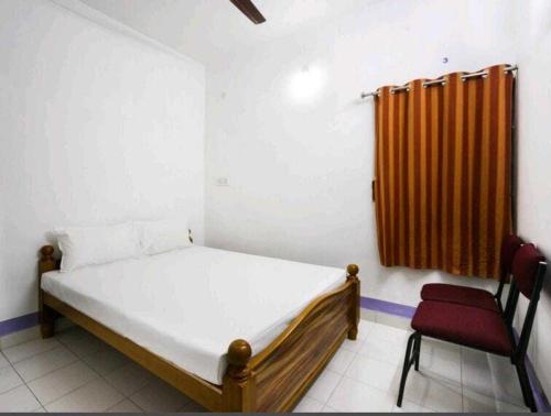 1 dormitorio pequeño con 1 cama y 1 silla en SPOT ON Shappy Inn Koyambedu Near PVR SPI Palazzo Chennai, en Chennai