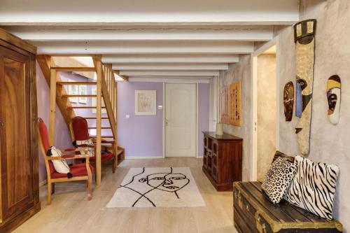 a living room with a couch and a staircase at La maison des vignes in Saint-Pierre-de-Bat