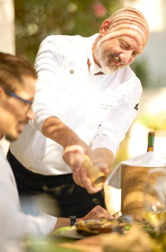 a chef preparing food on top of a table at Octant Vila Monte in Moncarapacho