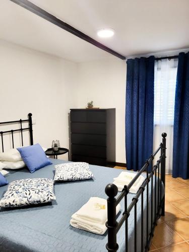 two beds in a bedroom with blue curtains at Casa da Belavista in Trofa