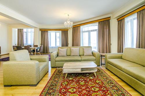 a living room with two couches and a table at Luxary Home Millennium in Baku