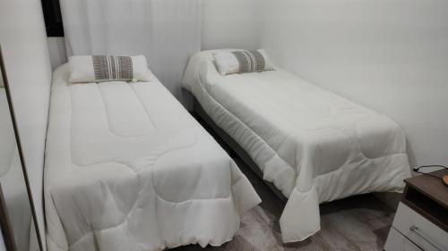 duas camas sentadas uma ao lado da outra num quarto em Duplex Pinamar norte frente al bosque em Pinamar