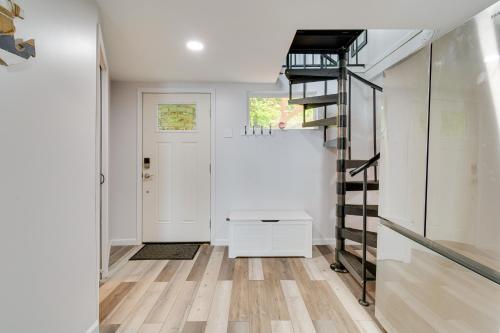 a hallway with a spiral staircase and a white door at Cozy Irondequoit Home on Lake Ontario! in Rochester