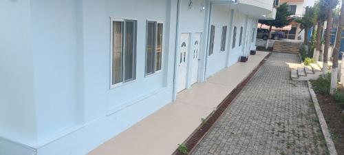 an empty sidewalk next to a white building at SeaSideGolem Apartments in Golem