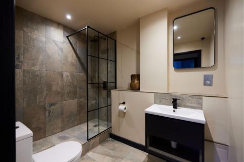 a bathroom with a toilet and a sink and a mirror at The Whitechapel Place - Stunning 2BDR Flat with Balcony in London