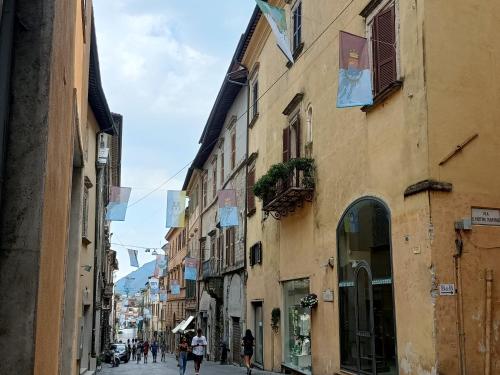 a group of people walking down a street with buildings at il CAPITELLO in Rieti