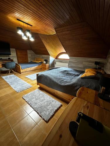 a bedroom with a bed and two rugs at Füle-Müle Élményház in Füle