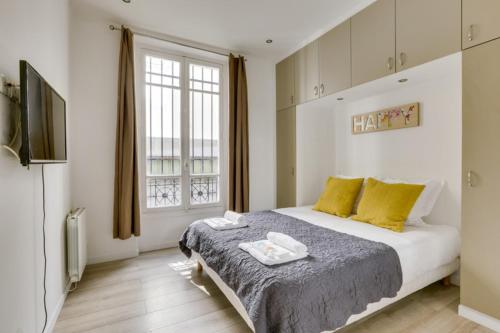 1 dormitorio con 1 cama grande con almohadas amarillas en 101greg en París