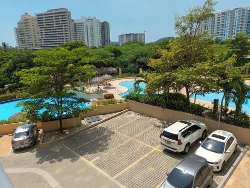 a parking lot with cars parked next to a pool at Beautiful Beach Apartment in Zazue in Santa Marta