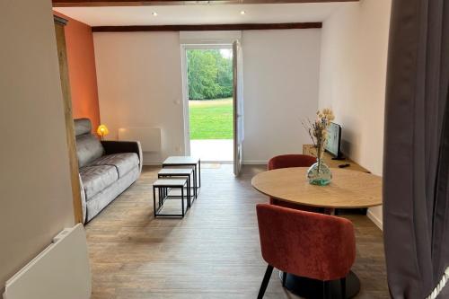 a living room with a couch and a table at Studio Lac chalain 30 m2 piscine chauffe in La Châtelaine