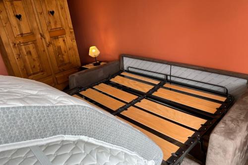 un lit vide dans une pièce avec une lampe dans l'établissement Studio Lac chalain 30 m2 piscine chauffe, à La Châtelaine