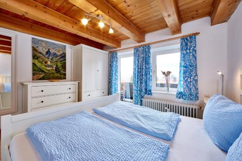 a bedroom with a bed and two windows at Ferienwohnung an der Ammer in Oberammergau