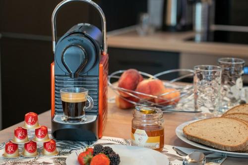 a coffee maker sitting on a table with fruit and bread at AU COEUR DES MONTAGNES in Pierrefitte-Nestalas