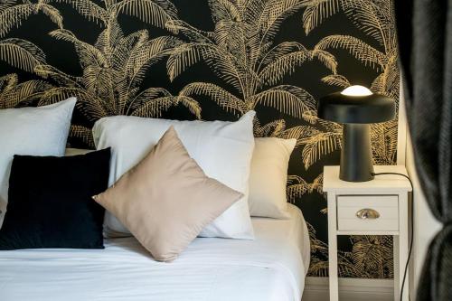 a bedroom with a bed with a black and gold wallpaper at AU COEUR DES MONTAGNES in Pierrefitte-Nestalas