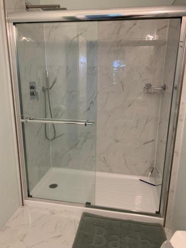 a shower with a glass door in a bathroom at Waterfront Q Estate summer cottage in Westport