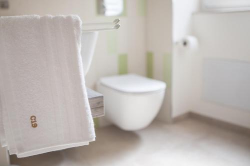 Baño blanco con aseo y toalla en Candelieri19, en Módica