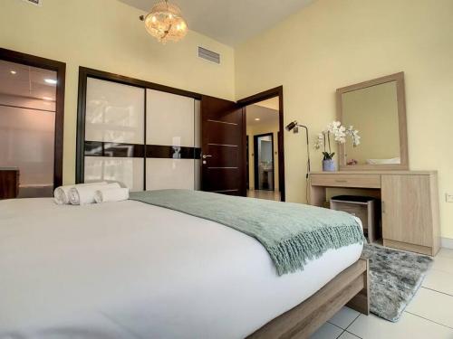 a bedroom with a large white bed and a mirror at Key View - Glitz 3, Tower 2 in Dubai