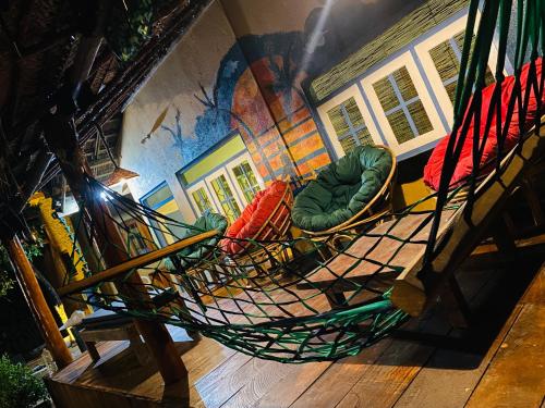 a hammock with chairs in a room with a mural at Muthu Hiriketiya in Dickwella