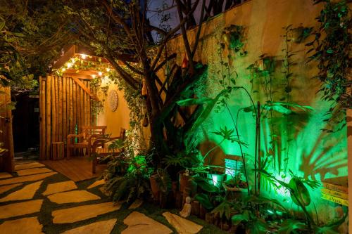 a garden with green lights on a wall at Petite Suite Juquehy - A 2 quadras do Mar - Pequena mas completa - 13 metros quadrados - Ar cond - Frigobar - Microondas - TV Smart - Serviço de Praia - Roupa cama e banho luxo - Wi Fi - Janelas e portas acústicas - Tudo Novo e cheiroso! in Juquei