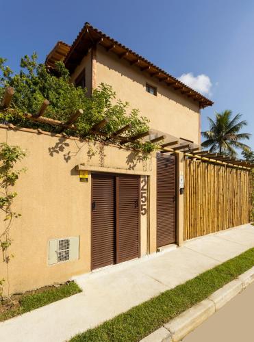 a house with two garage doors and a fence at Petite Suite Juquehy - A 2 quadras do Mar - Pequena mas completa - 13 metros quadrados - Ar cond - Frigobar - Microondas - TV Smart - Serviço de Praia - Roupa cama e banho luxo - Wi Fi - Janelas e portas acústicas - Tudo Novo e cheiroso! in Juquei