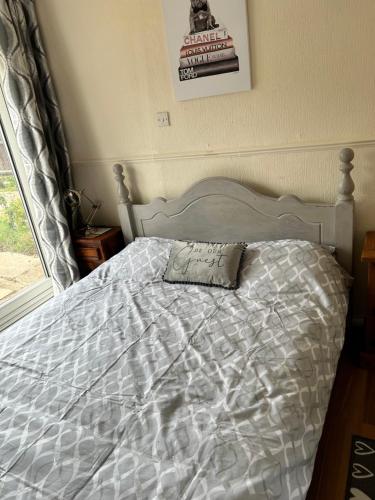 a bed with a white comforter and a pillow on it at Holly in Middlesbrough
