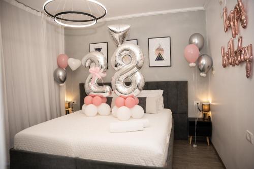a room with a bed with balloons and a number eight at צימר אדל - Zimmer Adel in Yavneʼel