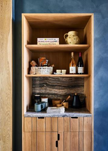 a wooden cabinet with bottles and dishes on it at Wildflower Farms, Auberge Collection in Gardiner