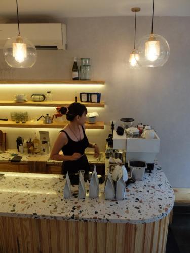 a woman standing in a kitchen preparing food at HALF Coffee N Dorm in Ho Chi Minh City