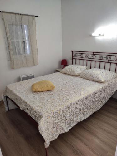 ein Schlafzimmer mit einem Bett mit gelbem Kissen darauf in der Unterkunft Jasse 632 in Gallargues-Le-Montueux