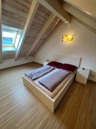 a bedroom with a large bed in a attic at Ferienwohnung mit Balkon in Oberelsbach