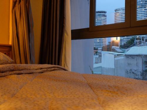 a bedroom with a bed and a window with a view at HALF Coffee N Dorm in Ho Chi Minh City