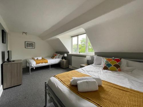 1 dormitorio con 2 camas y ventana en HUGE Apartment - 12min to City - FREE parking - Contractor Friendly - IRWELL STAYS en Mánchester