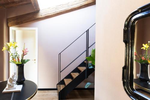 a staircase in a house with a mirror and a table with flowers at Residenza d'Epoca Visacci Valori Rooftop in Florence