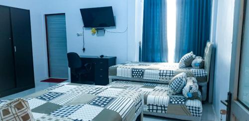 een slaapkamer met 2 bedden en een tv. bij Belimbing Bed & Breakfast in Lampuyang