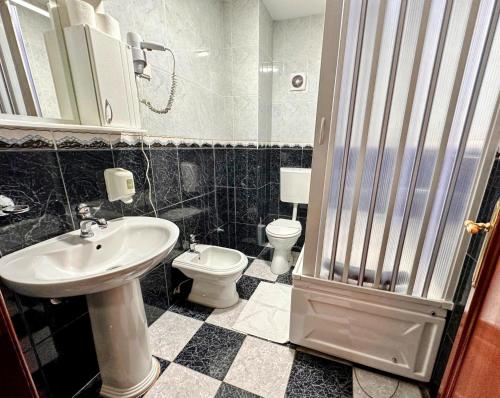 ein Bad mit einem Waschbecken und einem WC in der Unterkunft Hotel Čile in Kolašin