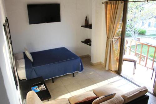 Habitación con cama, sofá y TV. en Hotel San Carlos Beach ., en San Carlos